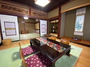 una sala da pranzo con tavolo e sedia di ゲストハウス山吹 a Toyama