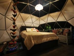 a bedroom with a bed in a triangular wall at Fantasia Glamping in Bogotá