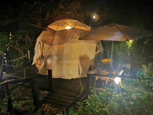 una mesa con una sombrilla junto a una mesa con en Fantasia Glamping, en Bogotá