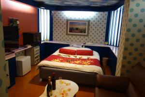 a bedroom with a bed and a table in it at Hotel Sha A Nai Yan (Adult Only) in Kishiwada