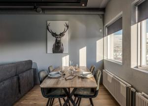 a dining room with a table and a deer picture on the wall at AK Rentals, with hot tubs in Akureyri