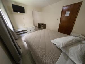 a bedroom with a large bed and a television at Nacional Park Hotel Lages in Lages