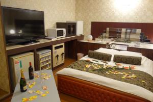 a bedroom with two beds and a flat screen tv at Hotel Sha A Nai Yan (Adult Only) in Kishiwada