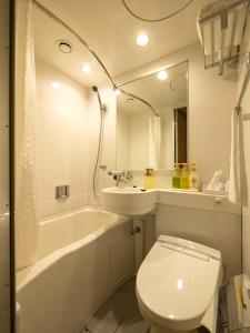 a bathroom with a toilet and a sink and a tub at EN HOTEL Hamamatsu in Hamamatsu