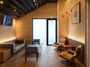a waiting room with chairs and a couch and a table at EN HOTEL Hamamatsu in Hamamatsu +29 photos