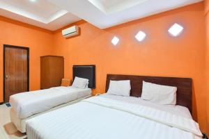 A bed or beds in a room at Sekar Ayu Hotel Malioboro Mitra RedDoorz