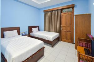 A bed or beds in a room at Sekar Ayu Hotel Malioboro Mitra RedDoorz