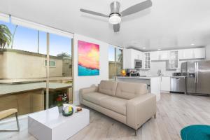 a living room with a couch and a kitchen at Heart of Mission Beach - Soft sandy beach walk to Cafés in San Diego