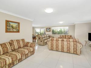 ein Wohnzimmer mit 2 Sofas und einem TV in der Unterkunft 44 Oaks Avenue in Long Jetty