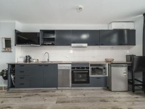 eine Küche mit Küchengeräten aus Edelstahl und schwarzen Schränken in der Unterkunft Nesuto Apartements Unit 533 in The Entrance