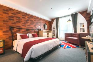 a bedroom with a bed and a brick wall at Yan's House Hotel in Kuta