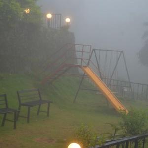 a playground in the fog with two benches and a slide at Mist WOODS VAGAMON in Vagamon