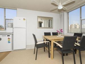 cocina y comedor con mesa y sillas en Tasman Towers Unit 13, en The Entrance