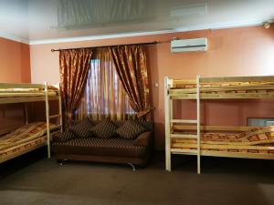 ネフテカムスクにあるОтель "ОСКАР"の二段ベッド2台とソファが備わる客室です。