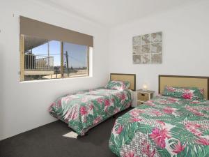 a bedroom with two beds and a window at Waterfront Unit 2 in The Entrance