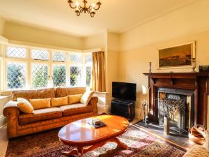 a living room with a couch and a fireplace at Yellow House on the Corner in Frinton-on-Sea