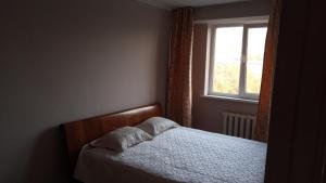 - une petite chambre avec un lit et une fenêtre dans l'établissement Apartment Shevchenko Panfilova, à Almaty