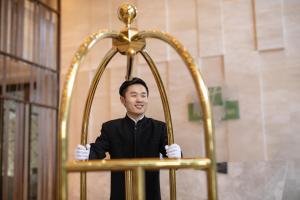 Un homme debout dans un autel d'or dans une pièce dans l'établissement Holiday Inn & Suites Langfang New Chaoyang, an IHG Hotel, à Langfang