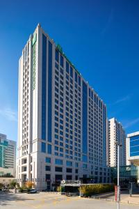 ein großes Gebäude mit blauen Fenstern in einer Stadt in der Unterkunft Holiday Inn & Suites Langfang New Chaoyang, an IHG Hotel in Langfang