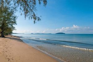a sandy beach with a tree and the ocean at Good Time Boutique Hotel in Sihanoukville