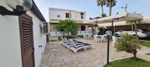patio con sedie, ombrellone e tavolo di Mare e Sole Villa Urso ad Avola