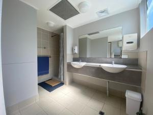 a bathroom with two sinks and a mirror at Homely Inn Hostel in Gold Coast