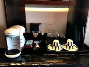 a kitchen counter with a coffee maker and glasses at InterContinental Guangzhou Exhibition Center, an IHG Hotel - Free Canton Fair Shuttle Bus and Registration Counter in Guangzhou