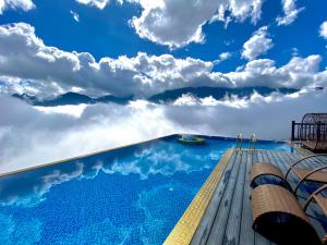 - une piscine avec un ciel bleu et des nuages dans l'établissement Pistachio Hotel Sapa, à Sa Pa