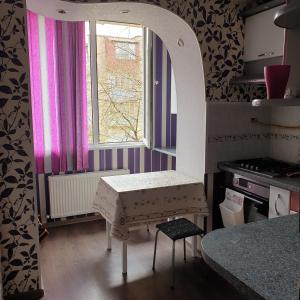 una pequeña cocina con mesa y ventana en Apartament cu 2 odai in chirie or.Soroca en Soroca