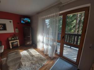 - un salon avec une grande fenêtre et une porte dans l'établissement 1 Bedroom cozy flat, à Pamporovo
