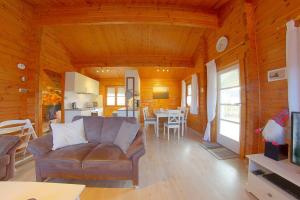 ein Wohnzimmer mit einem Sofa und einer Küche in der Unterkunft Ferienhaus Nordsee in Dorum Neufeld