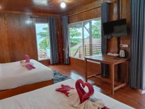 麗貝島的住宿－Sea To Moon Lipe，客房设有两张床、一张桌子和一台电视。