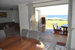 a dining room with a table and a view of the ocean at Hermanus Beach Club - Le Maree House 18 in Hermanus