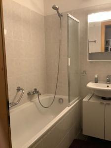 uma casa de banho com um chuveiro, uma banheira e um lavatório. em Dorril SUNNY & QUIET chalet 10 pers by Alpvision Résidences em Veysonnaz