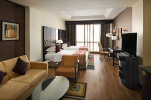 a hotel room with a bed and a living room at Crowne Plaza Al Khobar by IHG in Al Khobar