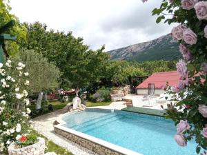 a swimming pool in a yard with flowers at KATY&MLADEN in Baška