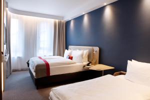 een hotelkamer met 2 bedden en een blauwe muur bij Holiday Inn Express - Darmstadt, an IHG Hotel in Darmstadt