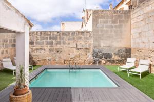 a swimming pool in the yard of a building at Rooms Can Moreno in Ses Salines