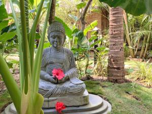 a statue of aitating woman holding a pink flower at Agonda Cottages in Agonda