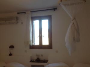 a bedroom with a window and a bed with white sheets at San Giorgio in Agios Georgios