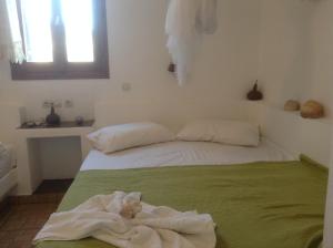 a bedroom with a bed with a green blanket at San Giorgio in Agios Georgios