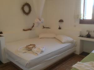 a bedroom with a white bed with a flower on it at San Giorgio in Agios Georgios