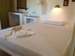 a white bed with a towel on top of it at San Giorgio in Agios Georgios