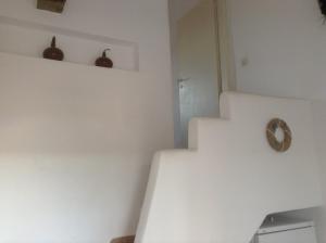 a white room with stairs and a clock on the wall at San Giorgio in Agios Georgios