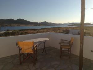 a table and chairs on a balcony with a view of the water at San Giorgio in Agios Georgios