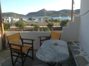 a table and chairs on a balcony with a view of the water at San Giorgio in Agios Georgios