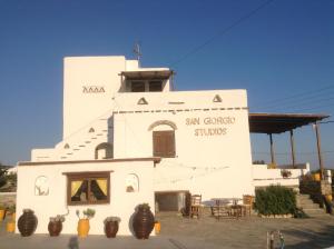 a white building with plants in front of it at San Giorgio in Agios Georgios