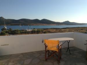 a table and chair on a balcony with a view of the water at San Giorgio in Agios Georgios