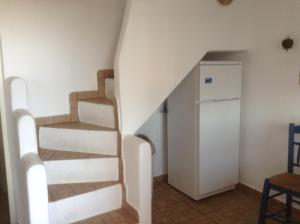 a spiral staircase in a room with a refrigerator at San Giorgio in Agios Georgios