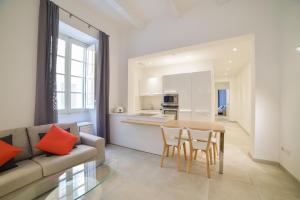 a living room with a couch and a table and chairs at CA1- City Central Apartment 1 in Valletta